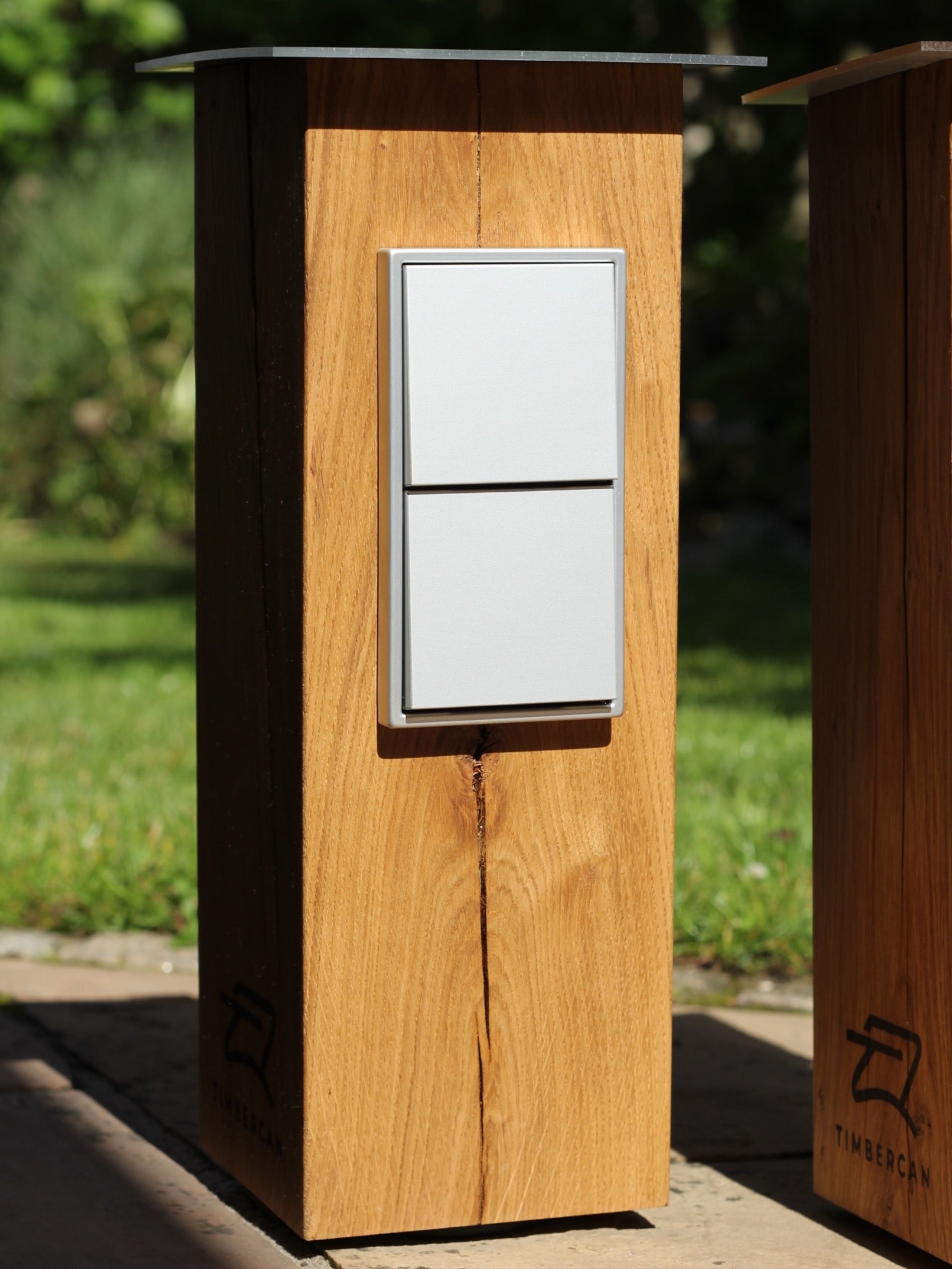 Silberne Steckdosensäule aus Eichenholz im Garten. 