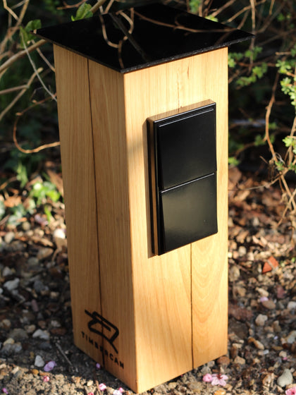 Steckdosensäule aus Massivholz in schwarz im Garten. 