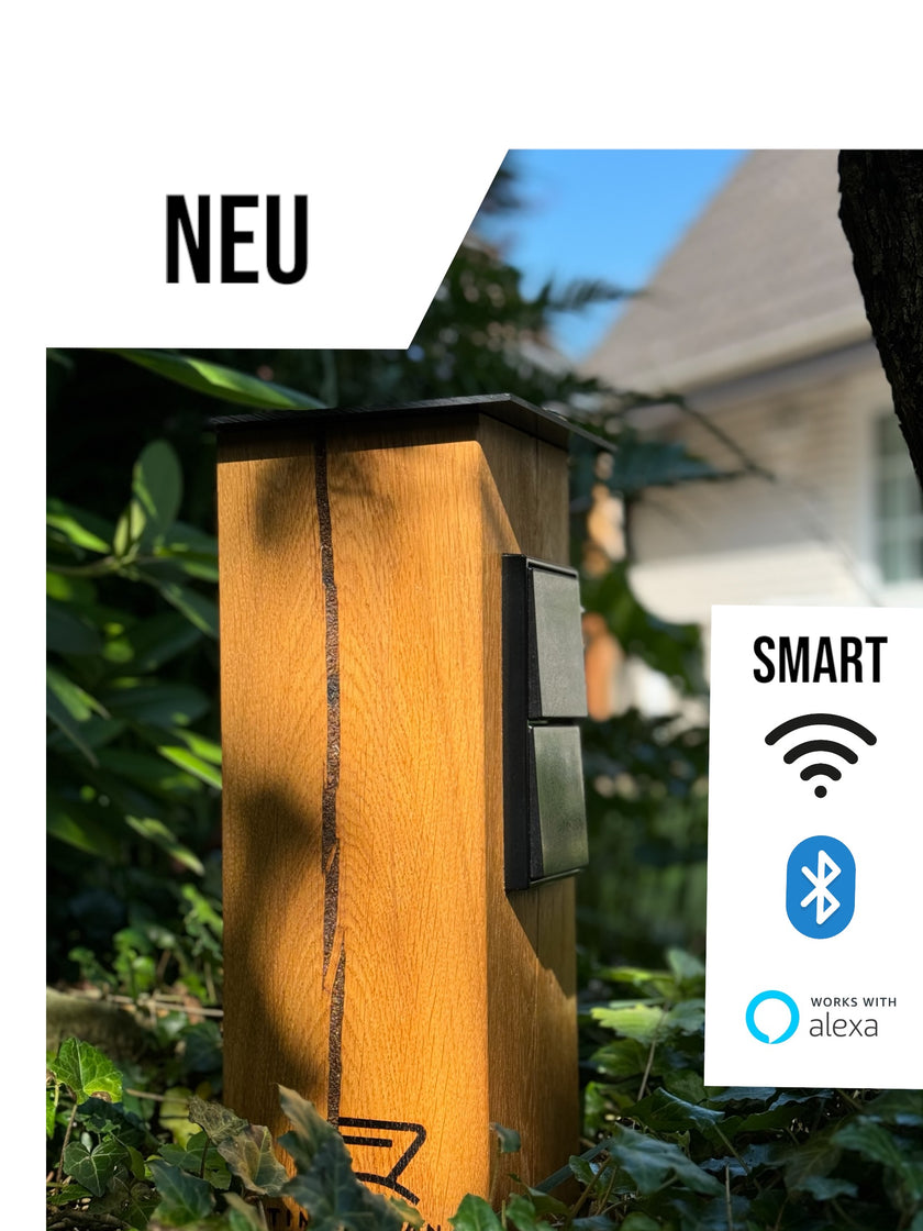 TIMBERCAN Steckdosensäule/Gartensteckdose aus Massivholz in der Ausführung mit WLAN und Bluetooth im Garten platziert. 