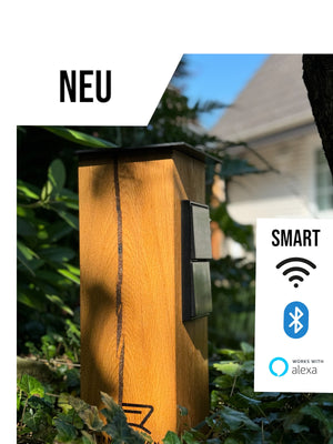 TIMBERCAN Steckdosensäule/Gartensteckdose aus Massivholz in der Ausführung mit WLAN und Bluetooth im Garten platziert. 